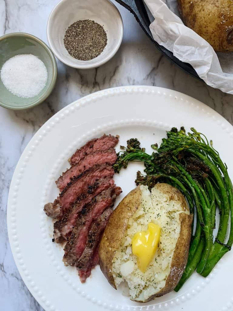 Instant Pot Baked Potatoes on a plate with sliced steak and baby broccoli