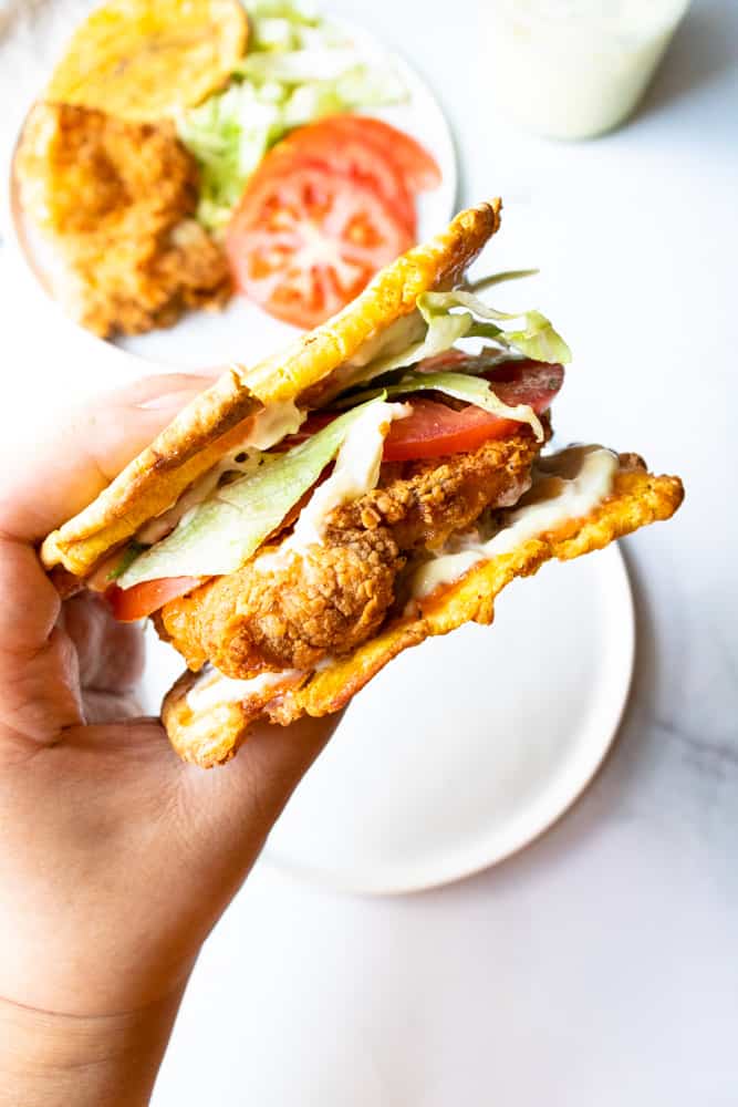 air fryer crispy chicken sandwich being held up over a plate