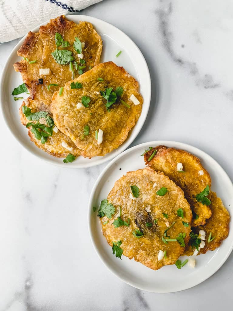 two plates of garlic tostones