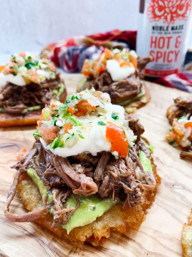 A close up of the spicy shredded beef tostadas where you can see the toppings