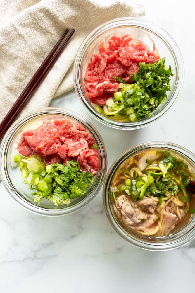 beef pho to go in three jars, one has been prepared and the other two have not