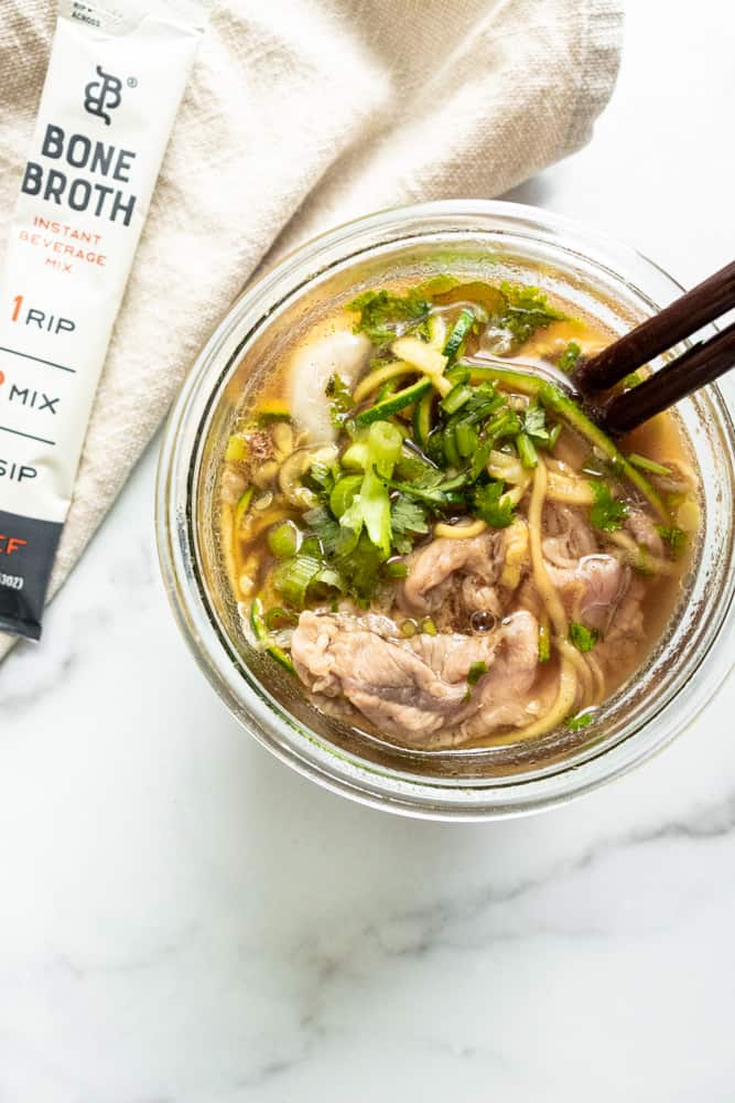 beef pho to go in a jar with chopsticks in it