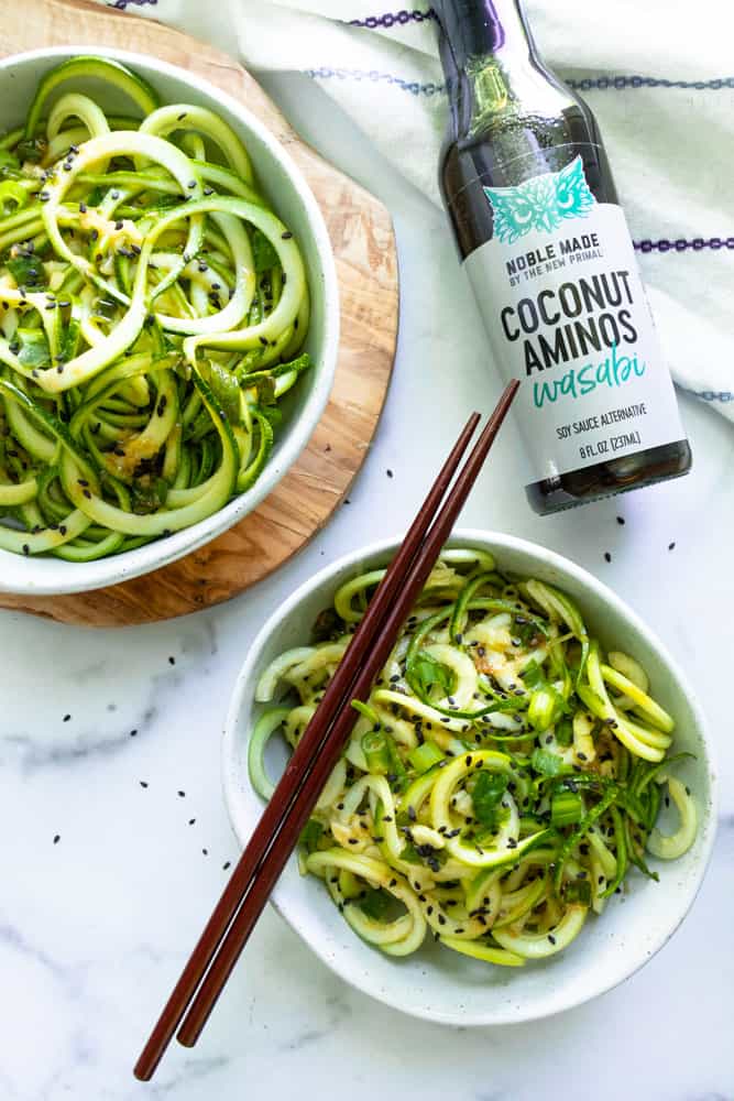 cold sesame wasabi noodles next to a bottle of wasabi coconut aminos