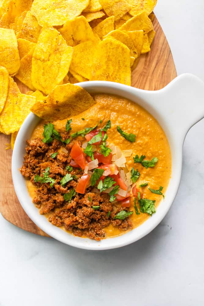 queso fundido con chorizo with a plantain strip dipped in it