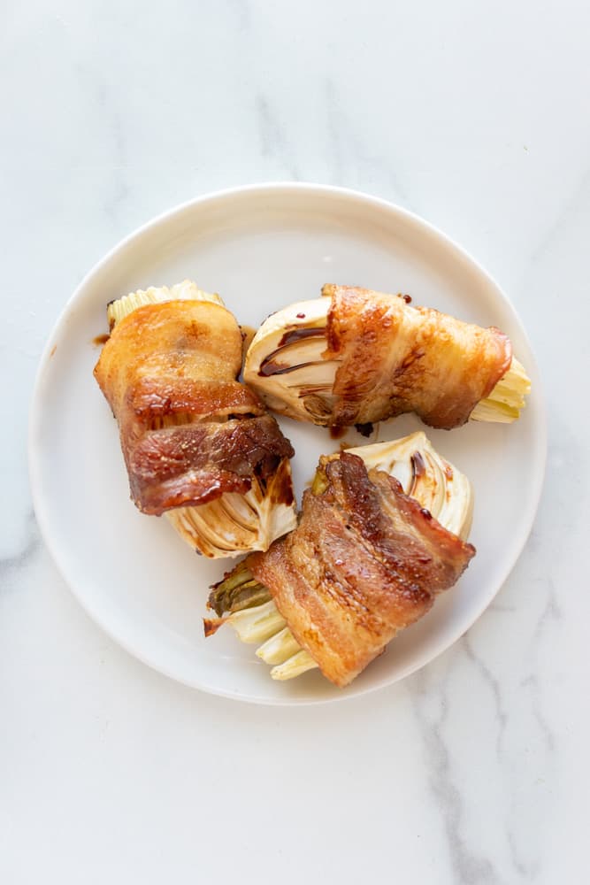 3 bacon wrapped fennel wedges on a small plate