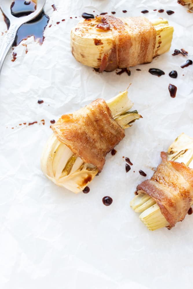 close up of two bacon wrapped fennel wedges