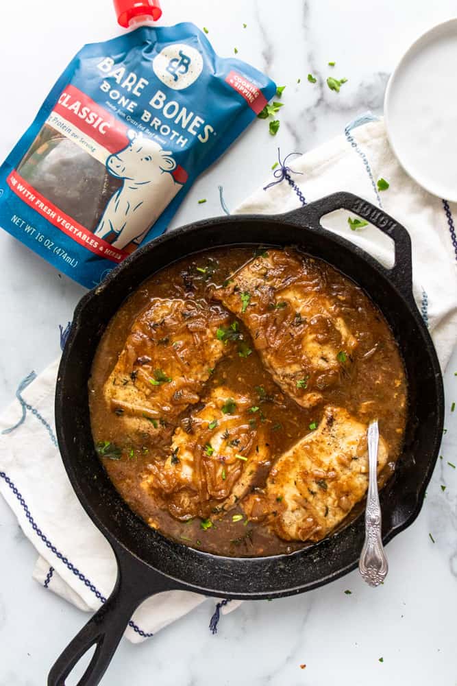 french onion smothered pork chops in a skillet