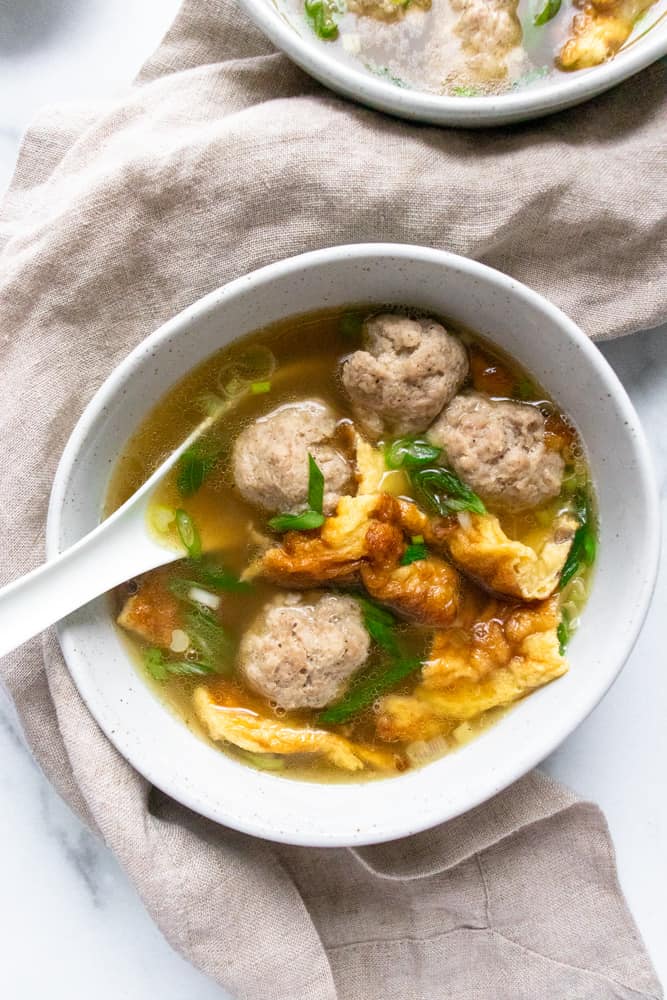 Thai Pork Omelette Soup in a bowl with a white spoon in it