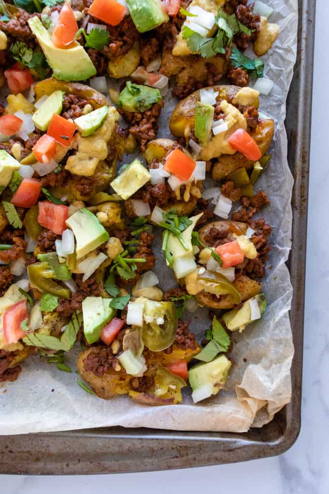 crispy smashed potato nachos on a baking sheet