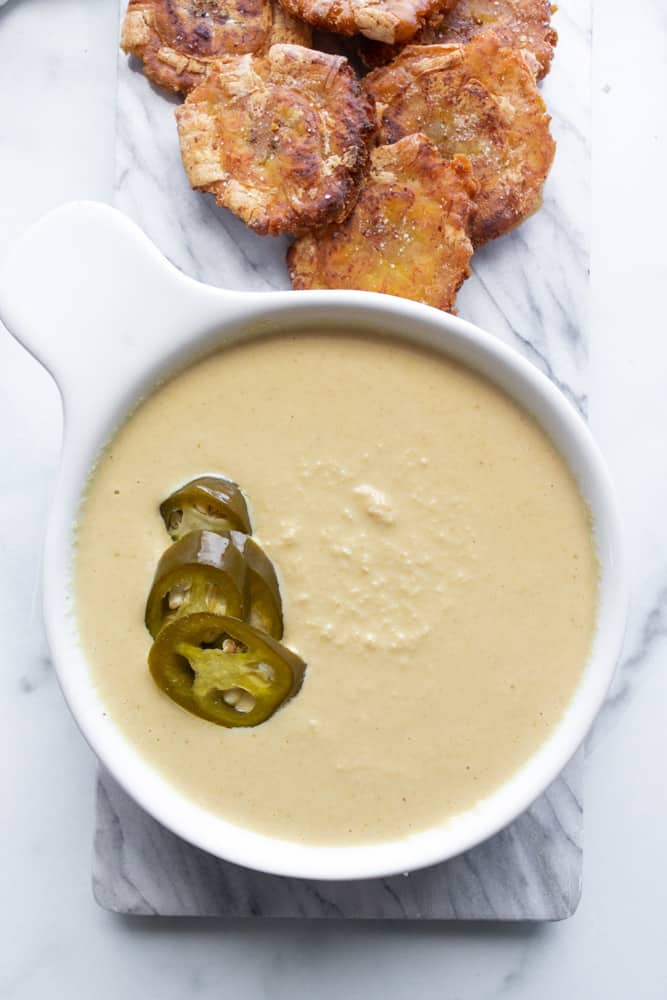 dairy free queso in a bowl with tostones