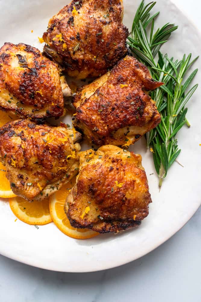 orange rosemary chicken on a play with fresh rosemary and orange slices