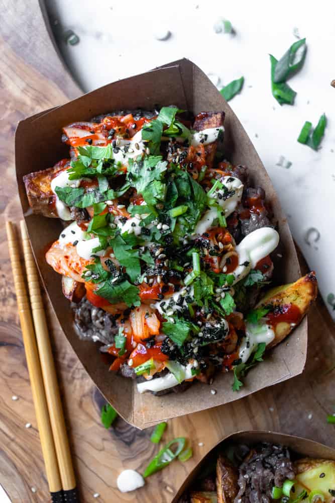 closeup of bulgogi kimchi fries next to chopsticks