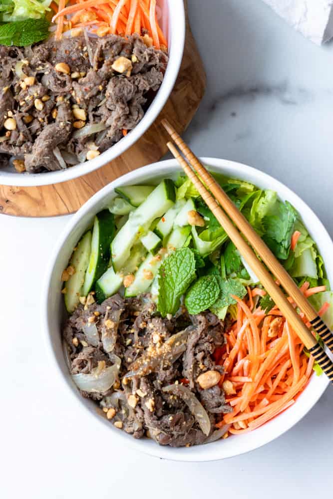 two bowls of bun bo xao (vietnamese lemongrass beef noodle) with chopsticks