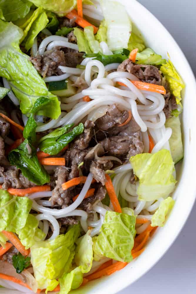 a bowl of bun bo xao (vietnamese lemongrass beef noodle) mixed