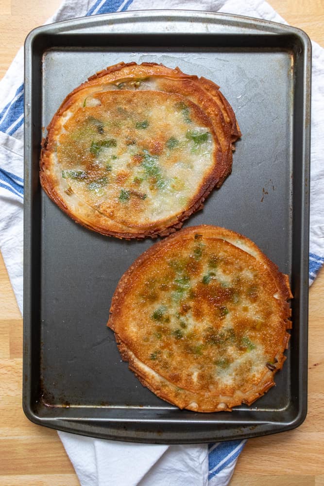 two easy scallion pancakes on a tray uncut