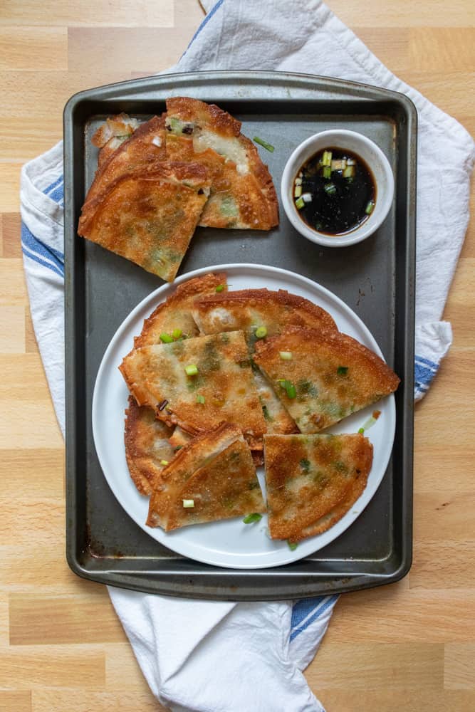 a plate of easy scallion pancakes on a tray with dipping sauce