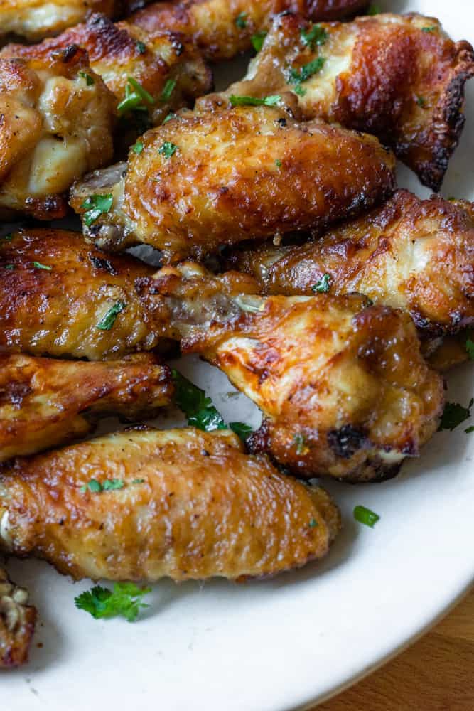 lao grilled chicken (pieng gai) on a plate garnished with cilantro