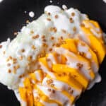 mango sticky rice on a black plate