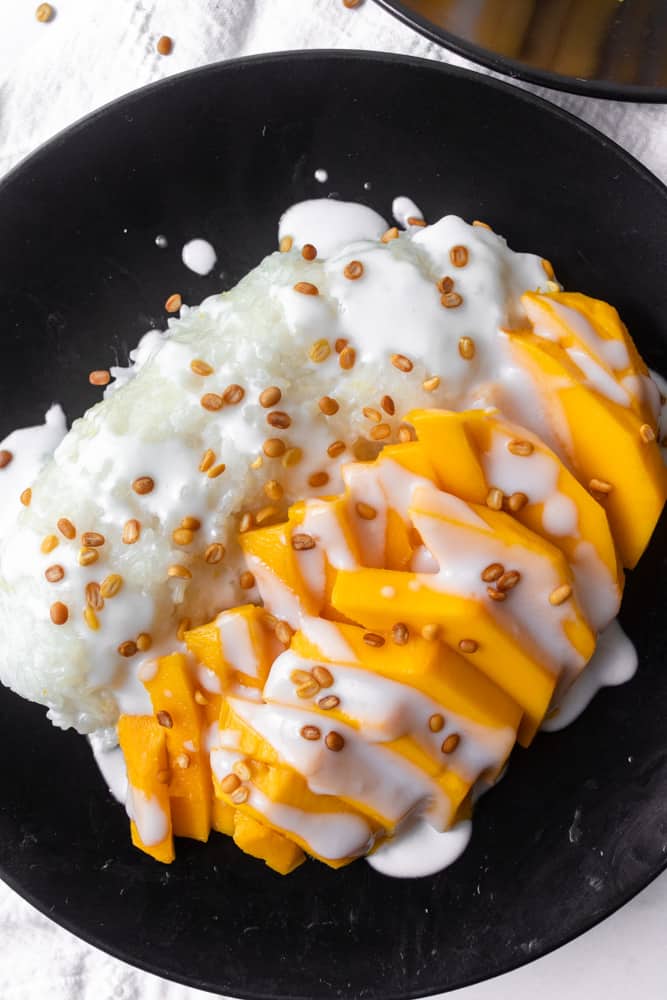 mango sticky rice on a black plate