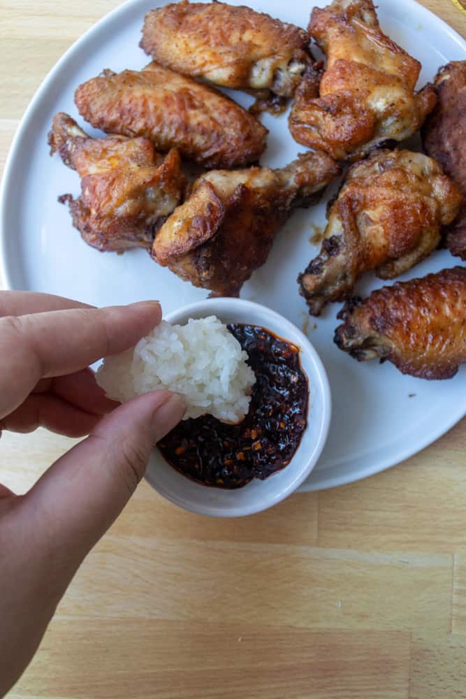 sticky rice (khao niew) being dipped into a sauce