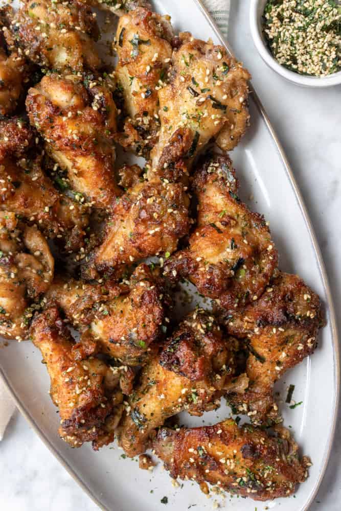 Furikake Chicken Wings on a platter next to a bowl of furikake